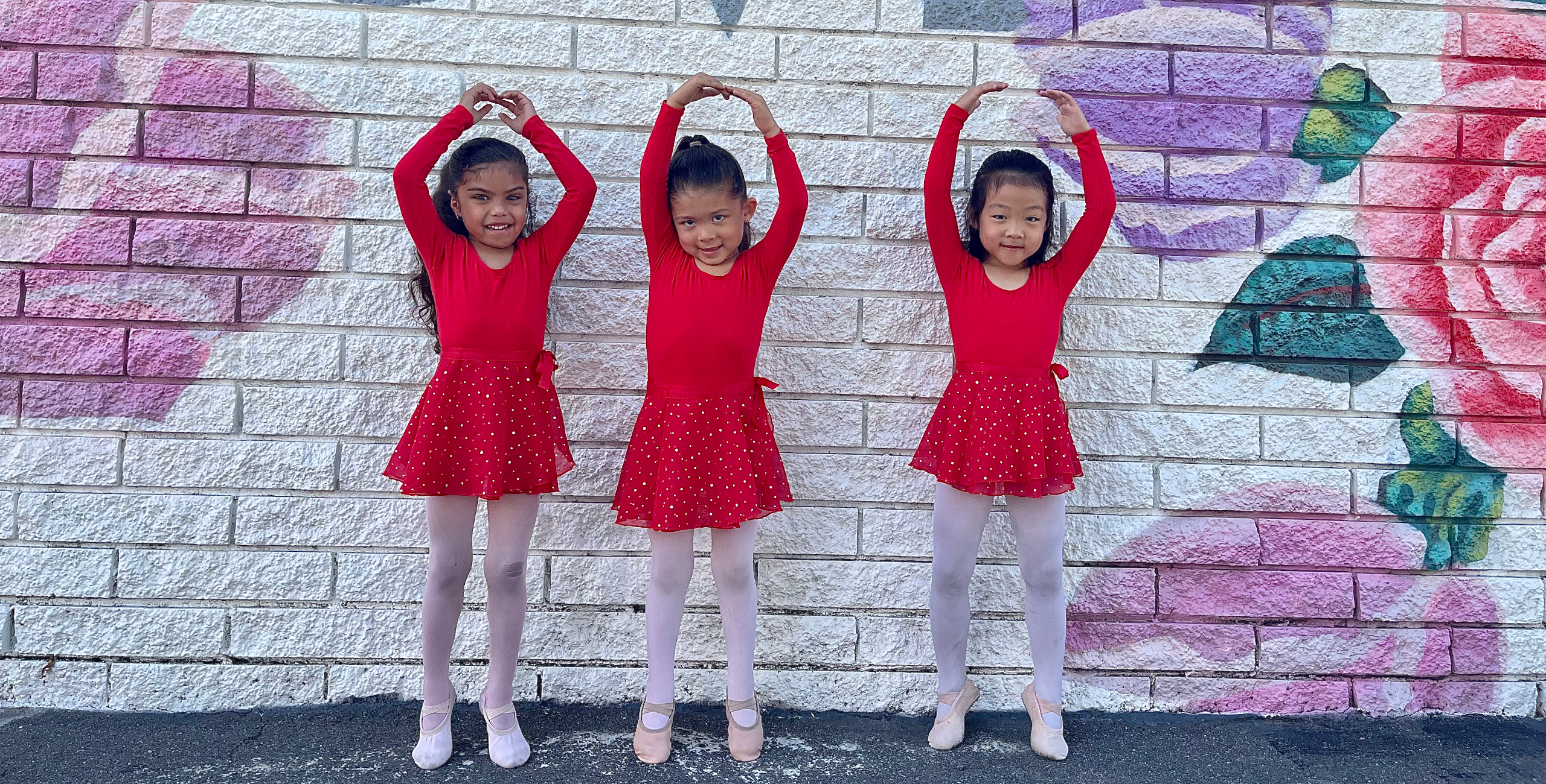 Three girls making a heart sign